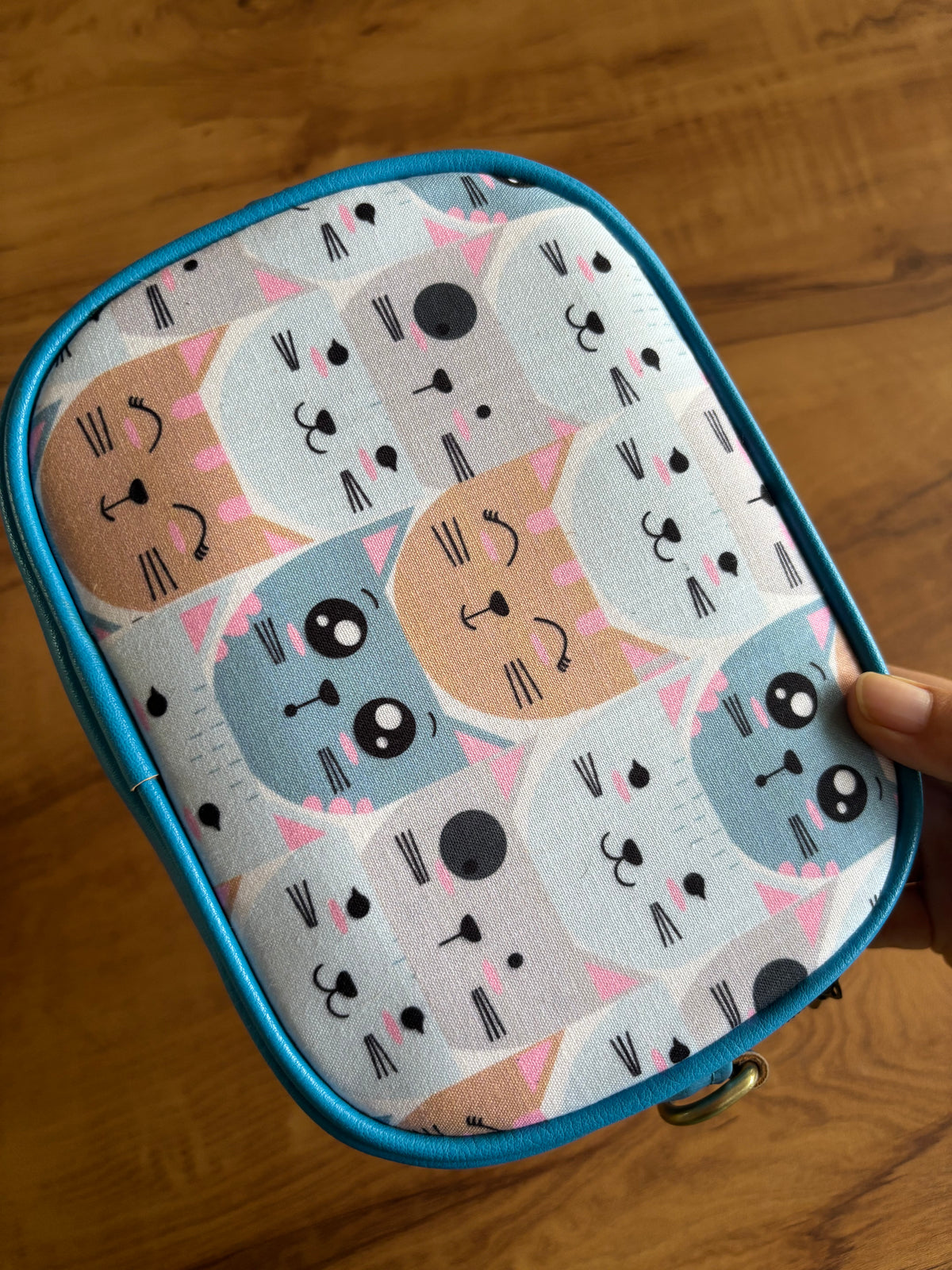 Close-up of the pastel cat-face print: pink, peach and blue kitties