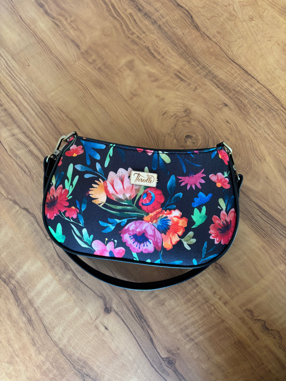 Night Garden Baguette Bag lying flat with its black clip-on strap