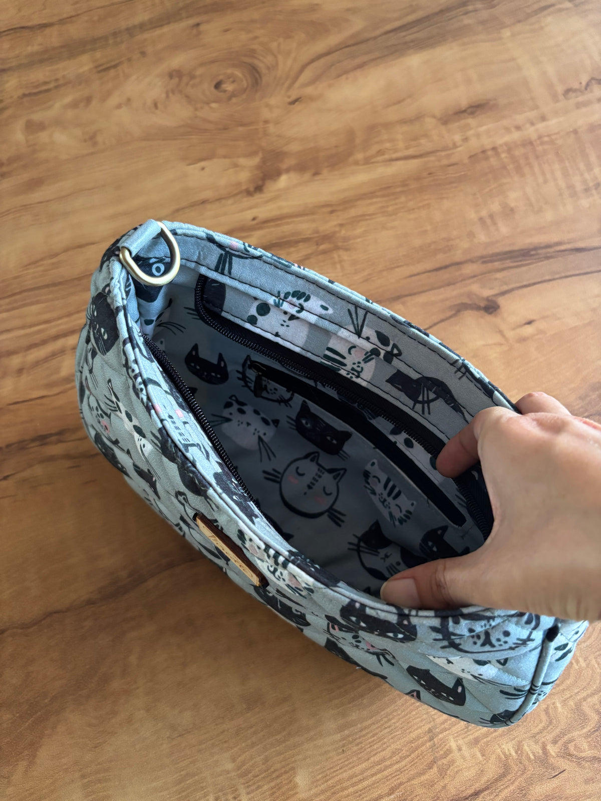 Inside the Kitty Faces Quilted Baguette Bag: lined in a grey cat print