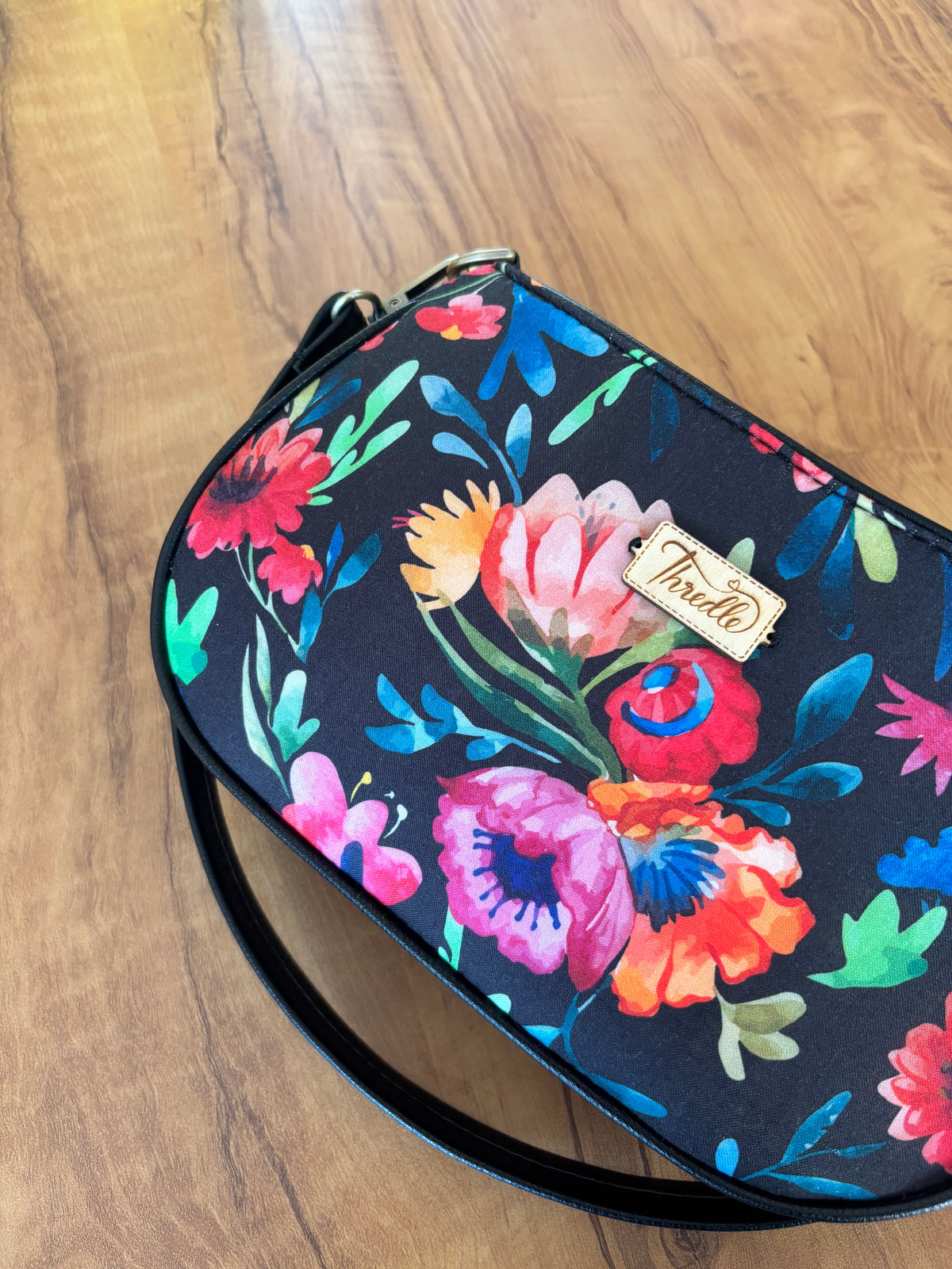 Close-up of the Night Garden Baguette Bag: coral, pink and violet flowers on black