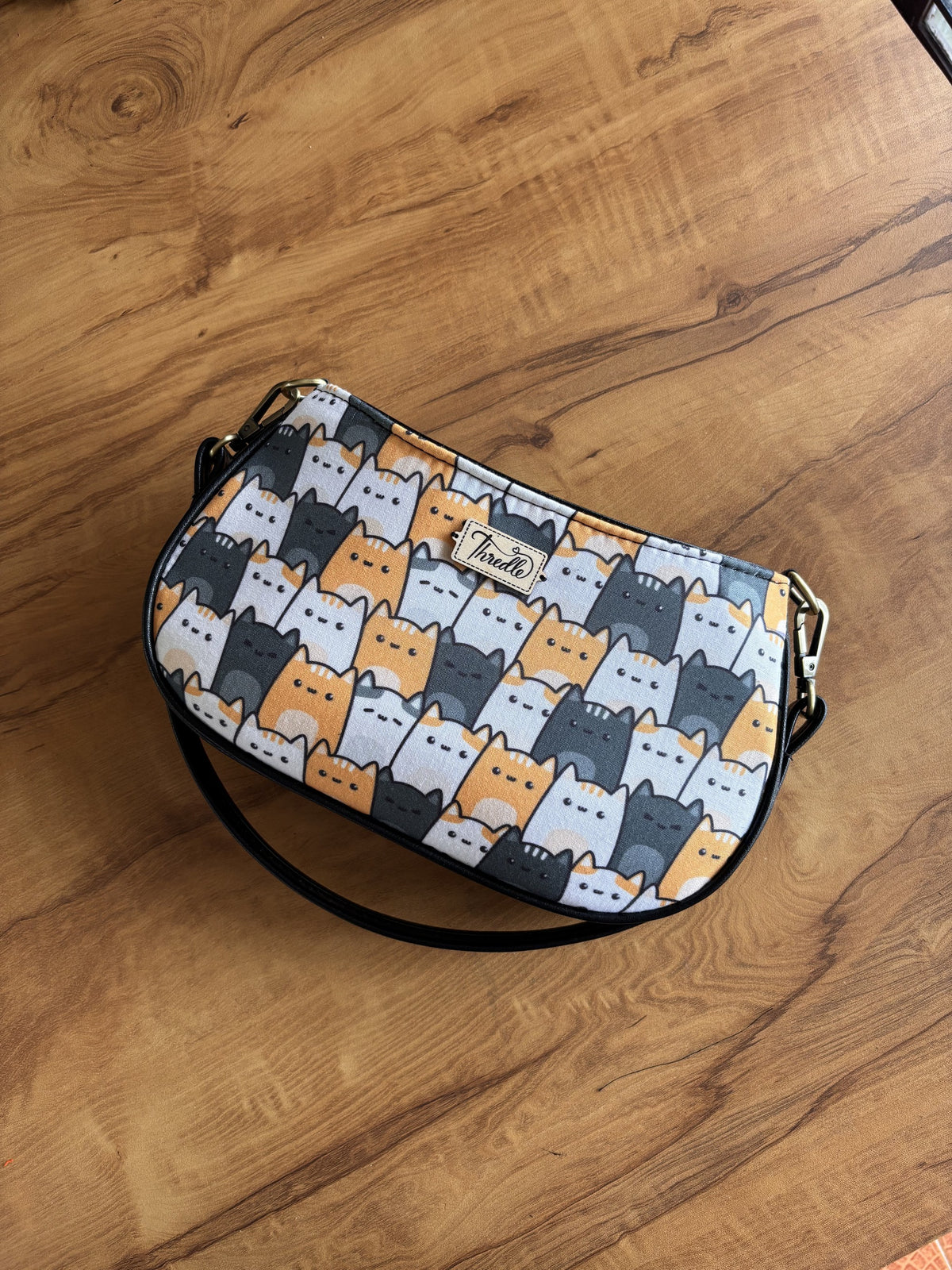 Catalicious Baguette Bag: ginger, grey and white cats stacked up, framed in black faux leather